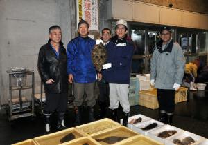 「黒部の魚」に選定されたヒラメを手に取る堀内市長